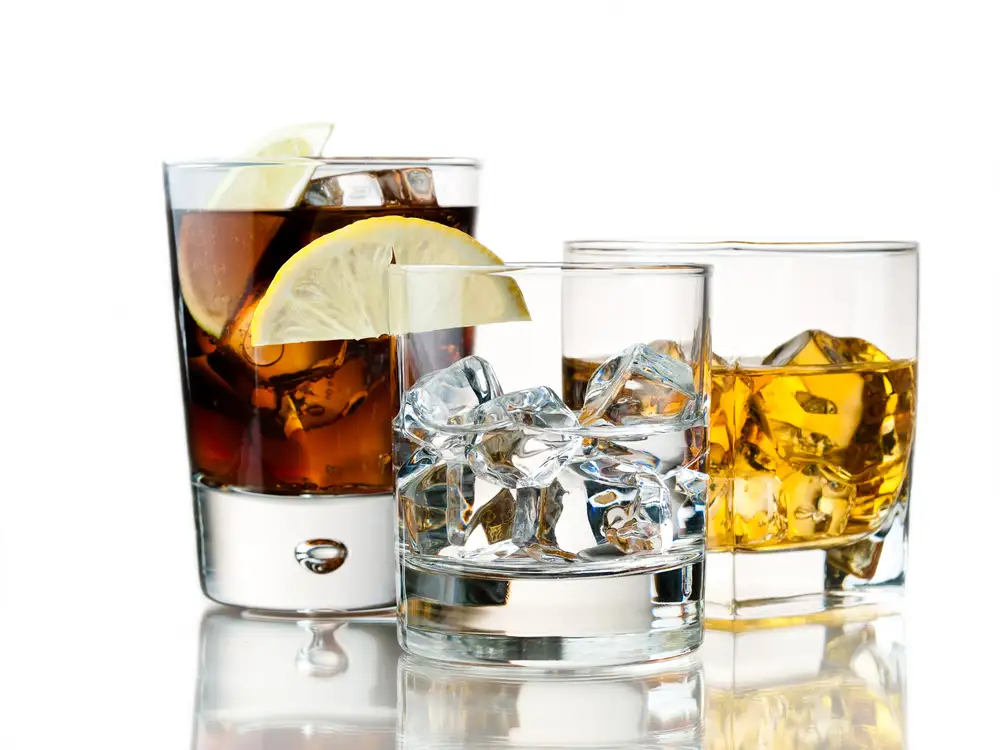 Glasses of alcohol close up on white background